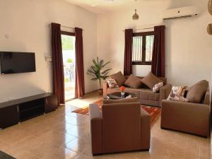 卢克索CASA LOKO Guest House的带沙发和平面电视的客厅
