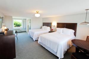 普罗温斯敦赛格拉斯Spa酒店的酒店客房设有两张床和一张桌子。