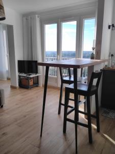 布鲁瓦LA SALAMANDRE的客厅设有一张木桌和椅子,客厅设有窗户