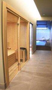 奥伦塞IMI Hotel & Spa的一间设有大玻璃门并通向浴缸的客房