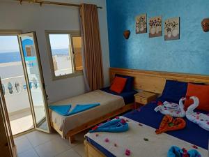 达哈布Dahab Beach Lodge的一间带两张床的卧室和一个阳台