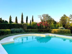 索纳安迪卡蒂莫拉德尔图尔科农家乐的花园内的游泳池,花园内种有树木和灌木