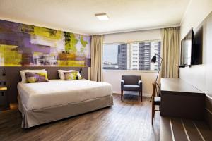 蒙得维的亚帕拉迪亚姆商务酒店的配有一张床、一张书桌和一扇窗户的酒店客房
