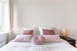 哥本哈根Penthouse with amazing views of Copenhagen!的一间卧室配有带粉红色枕头的床
