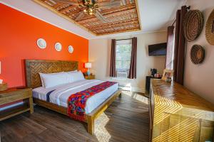 米尔福德La Posada的一间卧室拥有橙色的墙壁和一张床铺,天花板