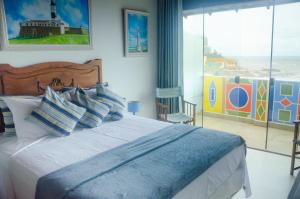 萨尔瓦多Pousada e Hostel Chez Marianne的一间卧室设有一张大床,享有海景