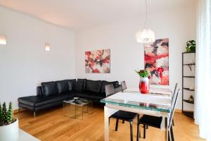 米兰San Siro Design Apartment的客厅配有黑色沙发和桌子