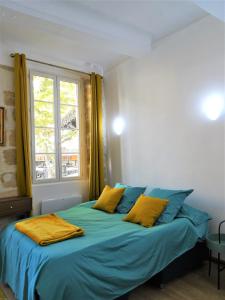 普罗旺斯艾克斯BLUE FOUNTAIN Luxueux Studio Aix Centre Historique -WIFI-SMART TV-的一间卧室配有一张带蓝色床单的床和一扇窗户。