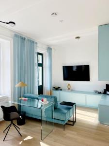 维也纳Sissi West的客厅配有蓝色的沙发和电视