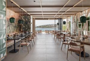 罗德岛卡利地亚Eden Roc Resort - All Inclusive的一间带桌椅并享有水景的餐厅