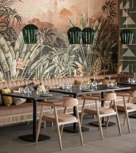 罗德岛卡利地亚Eden Roc Resort - All Inclusive的用餐室配有2张桌子和椅子以及壁画