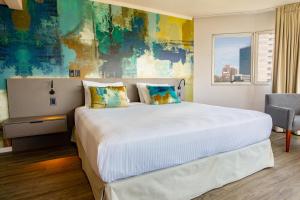 蒙得维的亚帕拉迪亚姆商务酒店的卧室设有一张白色大床和一扇窗户。