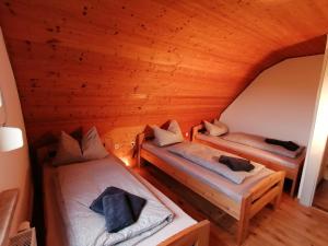 SchönaKäthes Sommerhaus的配有木天花板的客房内的两张床