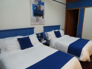 St-Raphael-de-BellechasseMotel Magistral的蓝色和白色的客房内的两张床