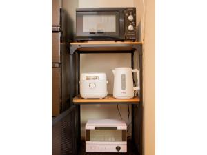 东京Forest Villa Togoshi - Vacation STAY 44284v的客房内的架子上有一个微波炉和烤面包机