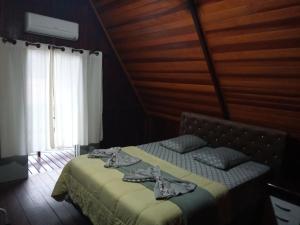 卡纳内亚Chalé Da Bia的木制客房内的一间卧室,配有一张床