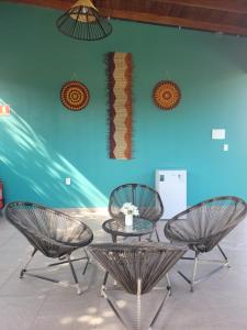 阿尔特杜尚Pousada Tauari的蓝色墙前的三把椅子和一张桌子
