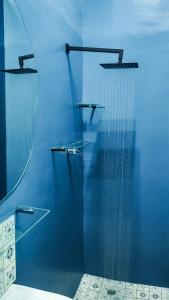 斯泰伦博斯1-bedroom apartment with secure basement parking的带淋浴的浴室,拥有蓝色的墙壁