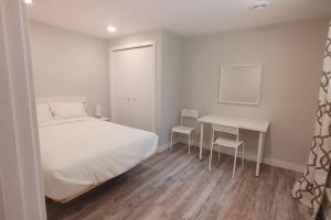 卡尔加里Beautiful 2 bedroom + office basement suite的卧室配有一张床和一张桌子及椅子