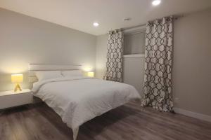卡尔加里Beautiful 2 bedroom + office basement suite的白色的卧室设有床和窗户