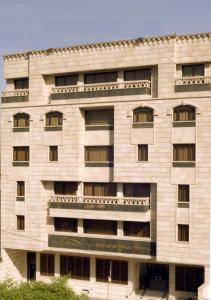 巴格达Shanasheel Palace Hotel的大型白色建筑,设有窗户