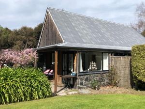 阿卡罗阿Tranquil Family Retreat的一间灰色屋顶的小房子