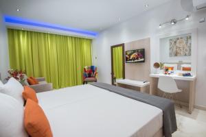 阿依纳帕Loutsiana Deluxe Apts的一间卧室配有一张大床和绿帘