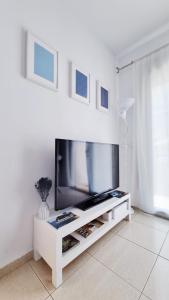 卡隆赫Costa Brava-St Antoni de Calonge apartament per parelles i famílies petites的一间客厅,客厅内配有一台电视,位于白色娱乐中心