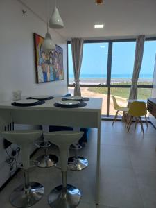 累西腓FLAT BEIRA MAR BARRA DE JANGADA RECIFE ANDAR ALTO的享有海景的厨房,配有桌椅