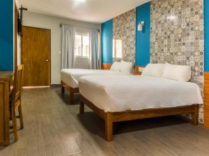 韦拉克鲁斯Hotel Meson del Barrio的蓝色墙壁客房的两张床