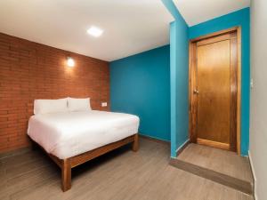 韦拉克鲁斯Hotel Meson del Barrio的一间卧室设有一张床和砖墙