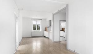 StokkemarkeHotel Stokkegaarden's BnB & Apartments的一间空的白色客房,设有厨房和镜子