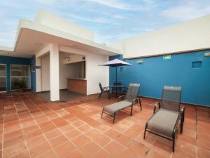 韦拉克鲁斯Hotel Meson del Barrio的一间设有椅子和桌子的房间,以及蓝色的墙壁