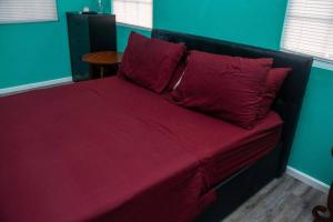 LaborieGlasgow Villa at La Mar的一张床上,床上有红色的床单和枕头