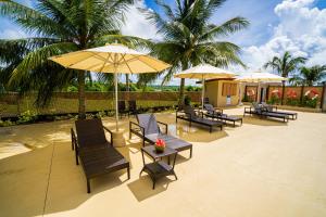 塞班Paradiso Resort & Spa的一个带桌椅和遮阳伞的庭院