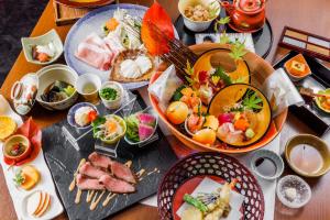 奈良KAMENOI HOTEL Nara的一张桌子上放着许多盘子的食物