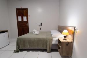 马卡帕Hotel Verde Mares的一间小卧室,配有床和床头柜
