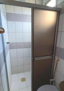 瓜拉派瑞Apartamento super arejado na Praia do Morro的带淋浴、卫生间和门的浴室