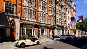 伦敦Deluxe Mayfair Luxury Apartment的停在大楼前的旧车