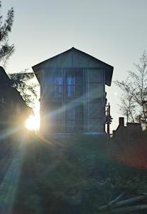 马尔万Chivarin Resorts的太阳落在后面的房子