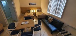 尼尔森湾Central Motel Nelson Bay的小房间设有床铺和桌椅
