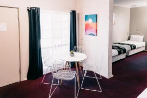 奥古斯塔港一品红汽车旅馆的配有桌椅和床的房间