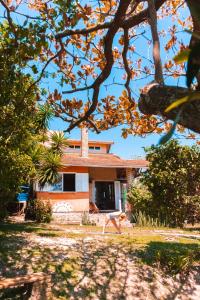 普腊亚罗萨Paikea Hostel Praia do Rosa的一座树木繁茂的院子中的房子
