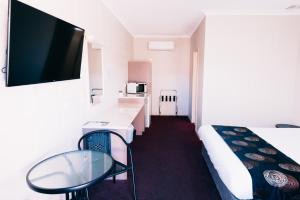 奥古斯塔港一品红汽车旅馆的客房设有1张床、1张桌子和1台电视。