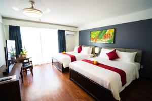 塞班Paradiso Resort & Spa的酒店客房设有两张床和电视。