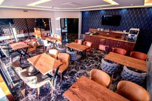 埃伯斯瓦尔德菲诺亚曼酒店的餐厅设有木桌、椅子和电视。