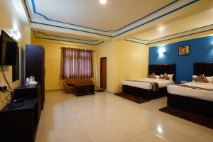 甘托克Hotel White Lotus Gangtok的酒店客房设有两张床和一台平面电视。