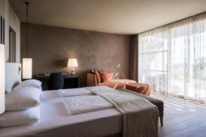 锡库利亚纳ADLER Spa Resort SICILIA的一间卧室设有一张大床和一个大窗户