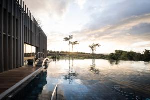锡库利亚纳ADLER Spa Resort SICILIA的棕榈树建筑旁边的游泳池