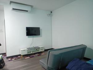 加影MyHOMESTAY 2 @ Vista Bangi的客厅配有椅子和墙上的电视